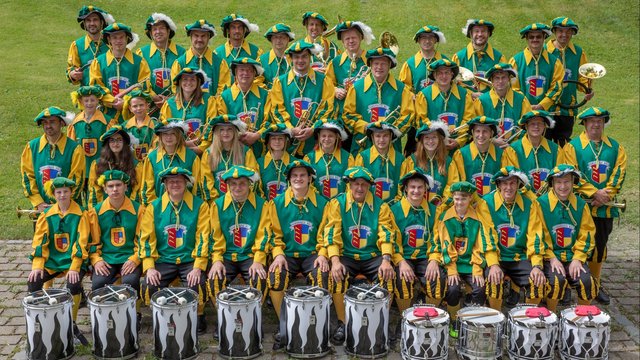 Gruppenfoto von den Mitgliedern des Fanfarenzugs boll im grün-gelben Landsknecht Häs